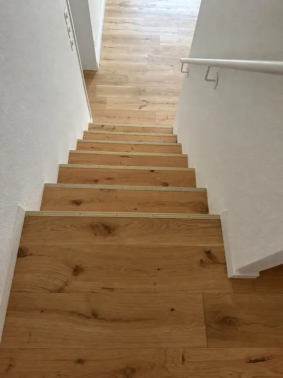 Holztreppe mit passend verlegtem Boden