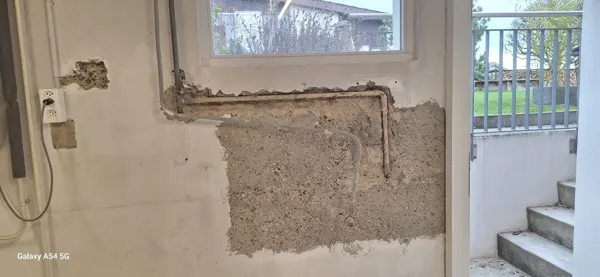 Freigelegte Wandfläche nach dem Rückbau in einer Waschküche in Baden